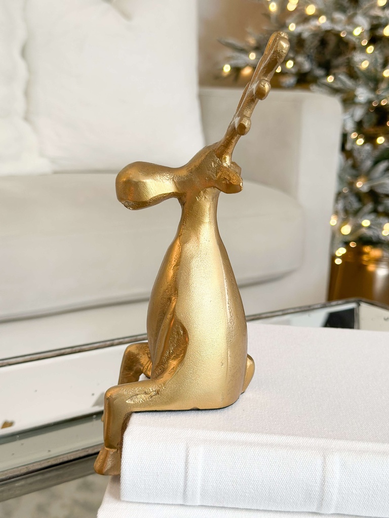 Venado de metal dorado sentado